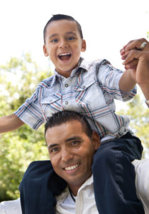 A man holding a boy on his shoulders.