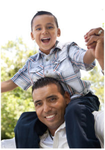 A man is holding a young boy on his shoulders.